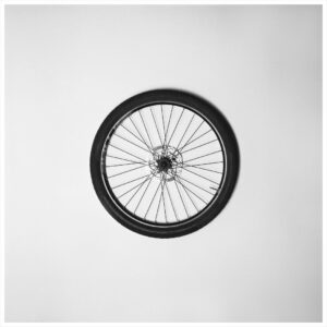 Rahgozar - photograph: a bicycle wheel on a white wall
